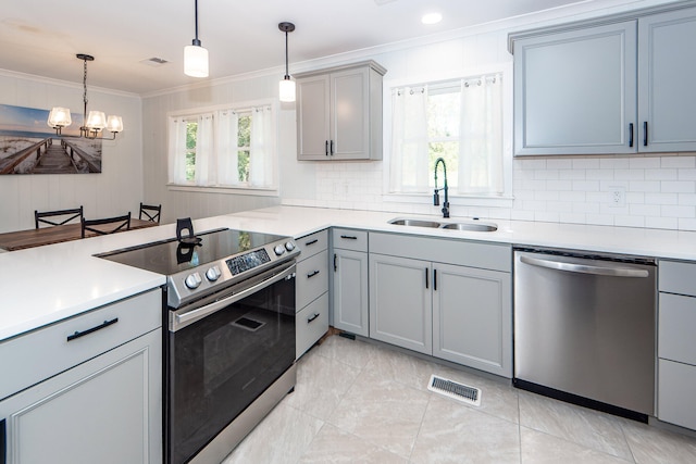 kitchen featuring sink, stainless steel appliances, decorative light fixtures, and ornamental molding