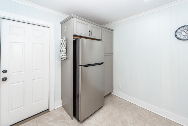 kitchen with wooden walls, ornamental molding, gray cabinets, and stainless steel fridge