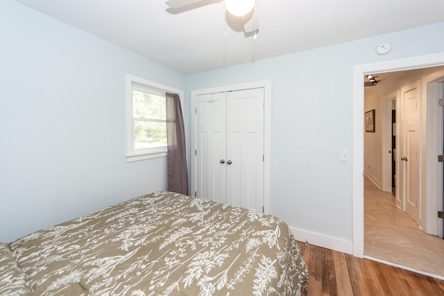 unfurnished bedroom featuring a textured ceiling, a closet, hardwood / wood-style flooring, and ceiling fan