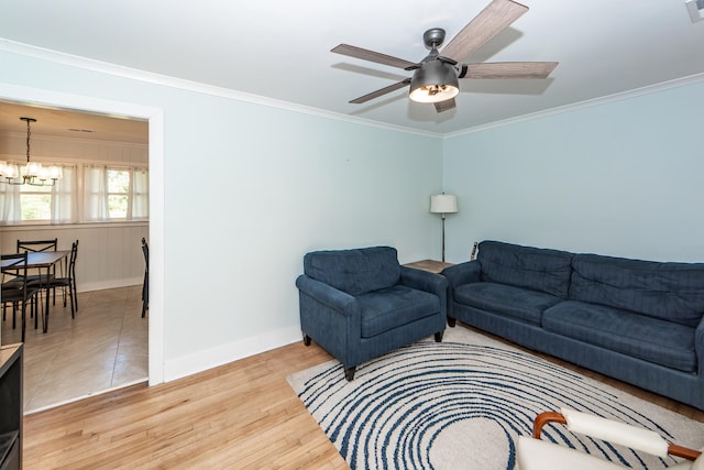 living room featuring ceiling fan with notable chandelier, crown molding, and light hardwood / wood-style floors