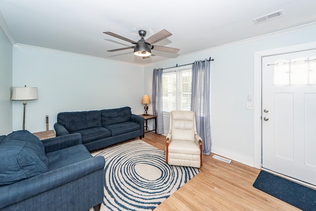 living room with crown molding, ceiling fan, and wood-type flooring