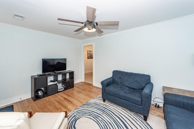 living room with light hardwood / wood-style flooring, ceiling fan, and ornamental molding