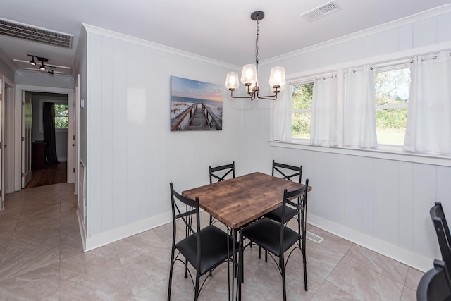 dining room featuring wood walls, crown molding, and a notable chandelier