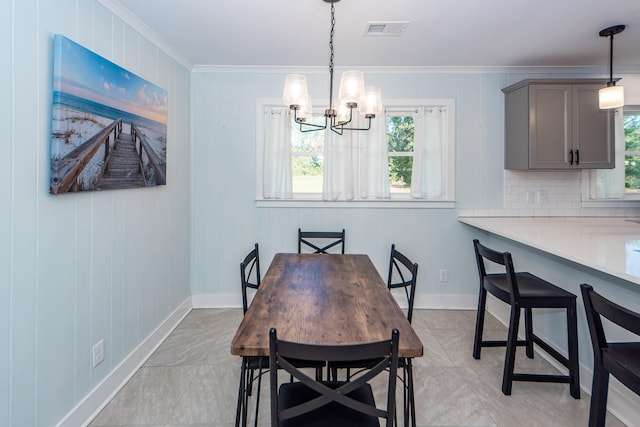 dining room with wood walls, ornamental molding, and an inviting chandelier