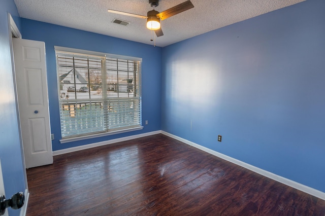 empty room featuring dark hardwood / wood-style flooring, a textured ceiling, and ceiling fan