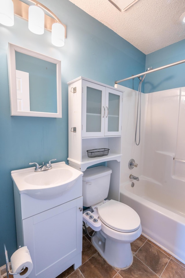 full bathroom with vanity, toilet, washtub / shower combination, and a textured ceiling