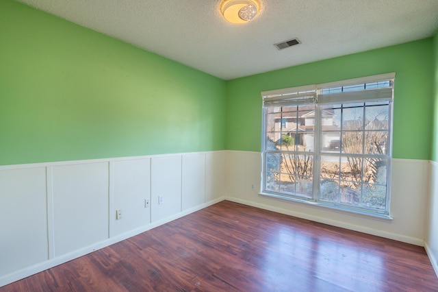 spare room with dark wood-type flooring and a textured ceiling