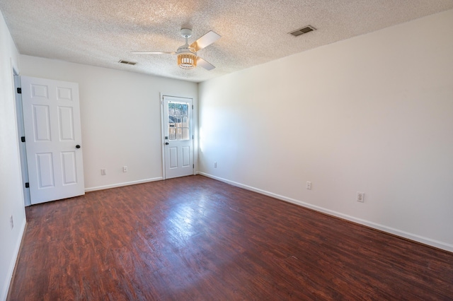 empty room with ceiling fan, dark wood-type flooring, and a textured ceiling