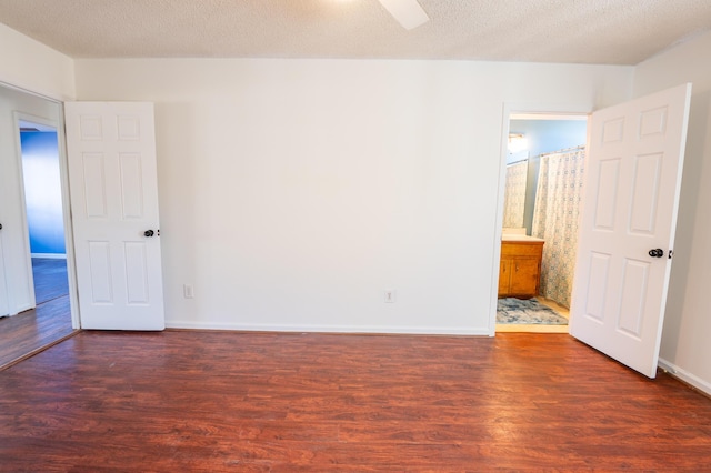 unfurnished room featuring a textured ceiling and dark hardwood / wood-style floors