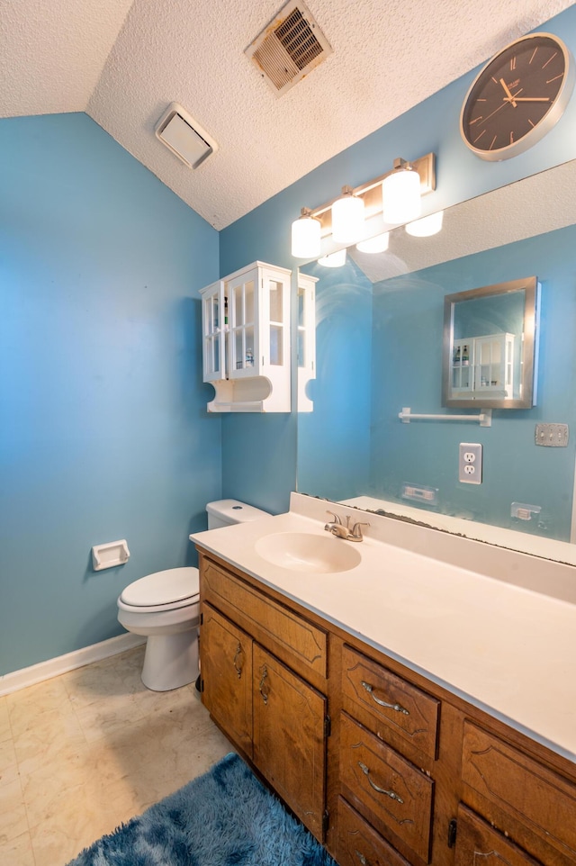 bathroom featuring a textured ceiling, vanity, vaulted ceiling, and toilet