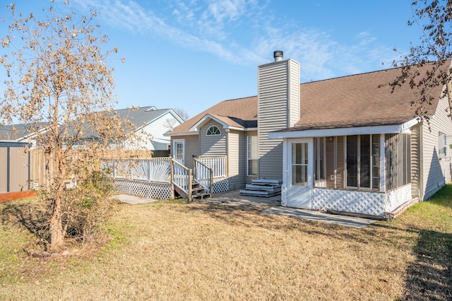 back of house with a wooden deck, a sunroom, and a yard