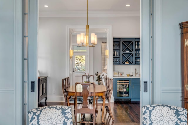dining room featuring beverage cooler, dark wood-type flooring, a chandelier, ornamental molding, and recessed lighting
