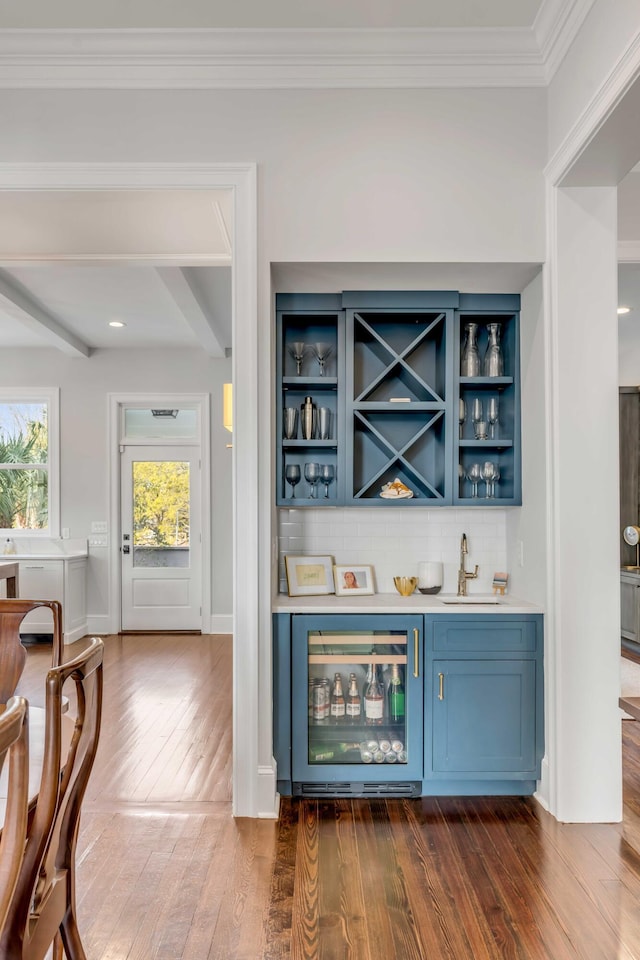 bar with wine cooler, a sink, wet bar, decorative backsplash, and dark wood-style floors