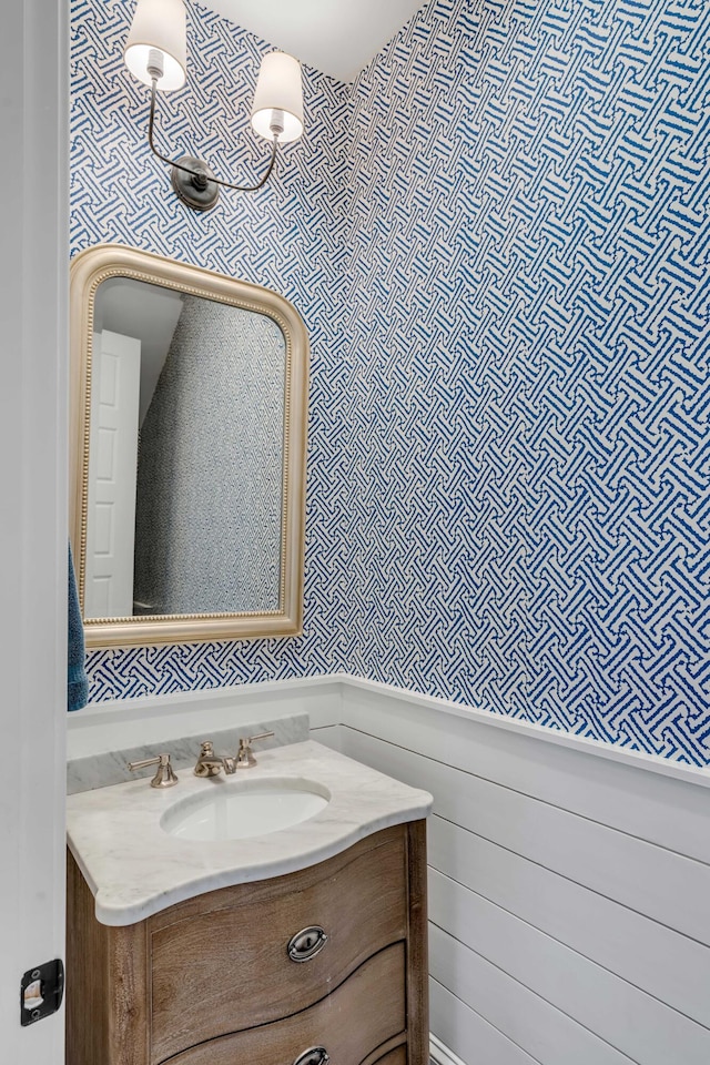 bathroom featuring vanity and wallpapered walls