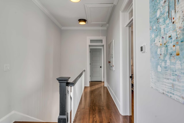 hallway with attic access, baseboards, crown molding, an upstairs landing, and dark wood-style floors
