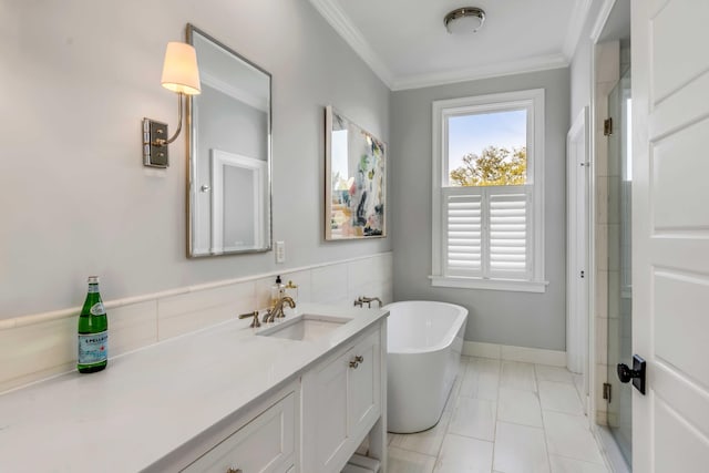 bathroom with marble finish floor, vanity, crown molding, a freestanding bath, and baseboards