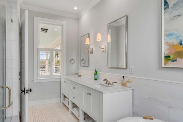 full bathroom featuring double vanity, crown molding, a stall shower, and a sink