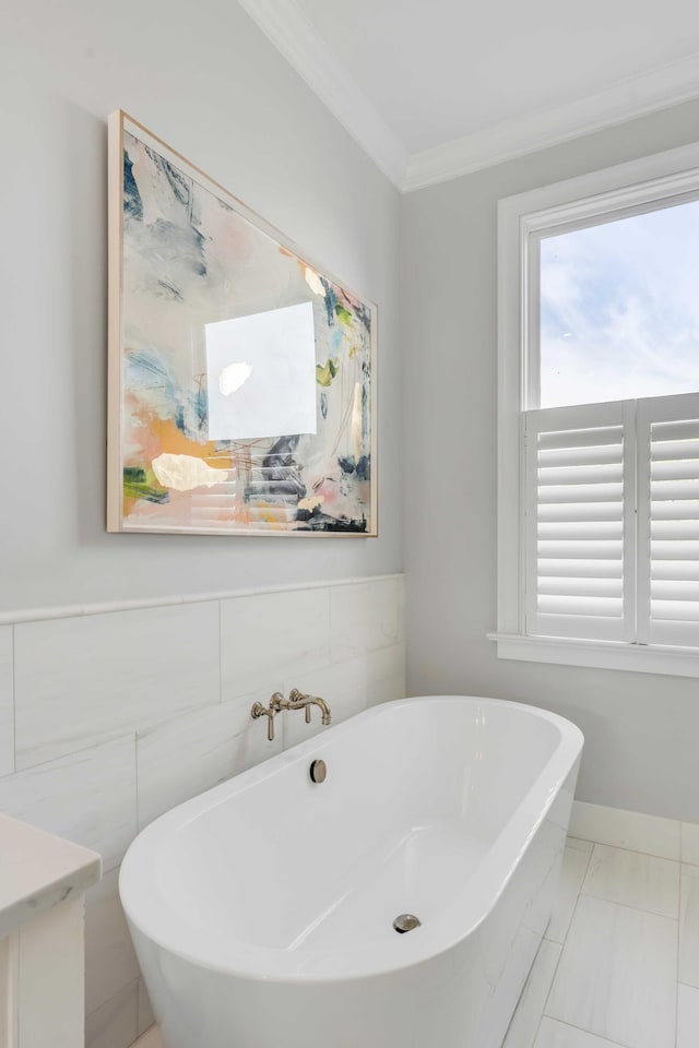 full bathroom with a freestanding bath, ornamental molding, and a healthy amount of sunlight