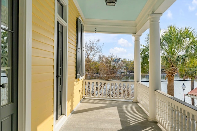 balcony featuring a water view and a porch