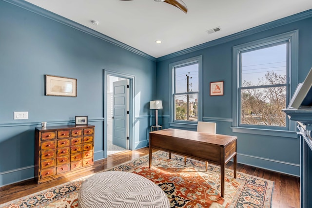 office space with baseboards, ceiling fan, visible vents, crown molding, and wood finished floors