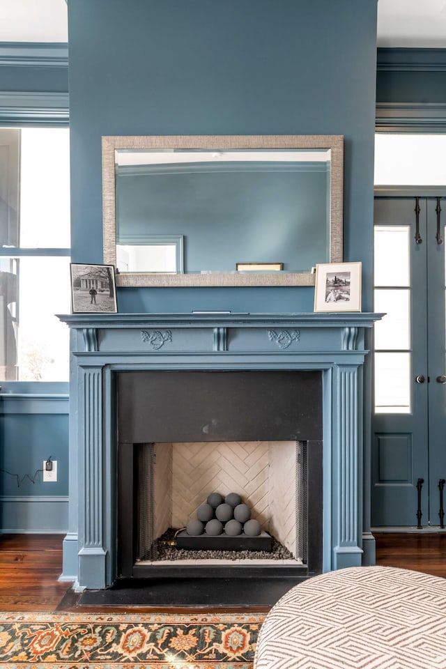 interior details with baseboards, a fireplace, and wood finished floors