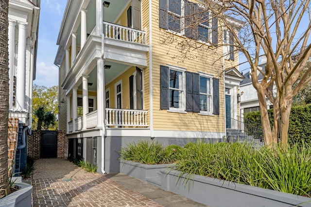 view of property exterior with a balcony and a porch