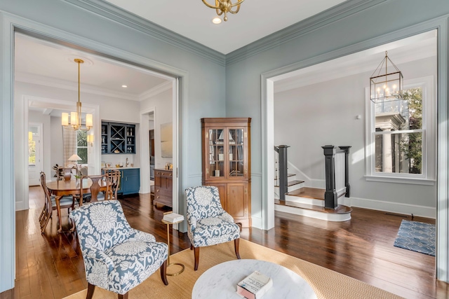 sitting room with a chandelier, baseboards, hardwood / wood-style floors, and stairway