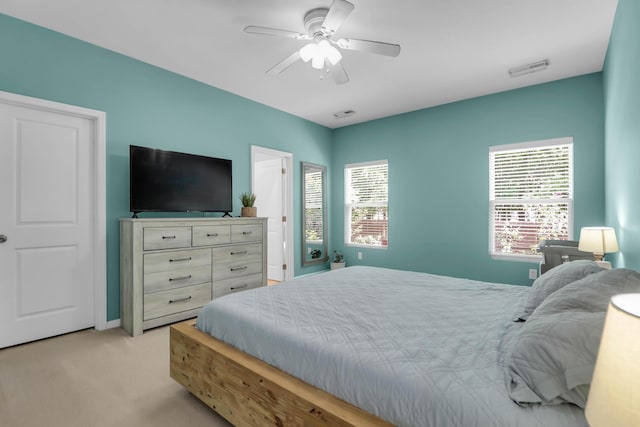 bedroom featuring light colored carpet, a ceiling fan, and baseboards