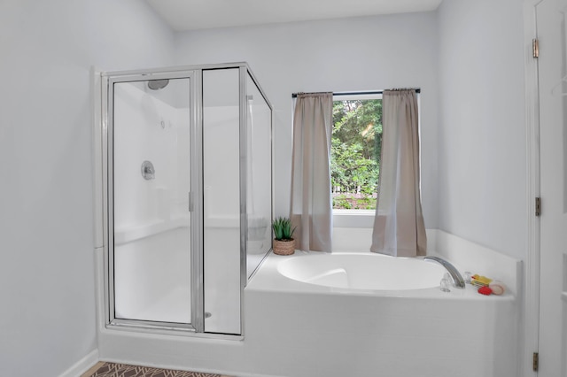 full bathroom with a bath and a shower stall