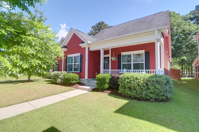 view of front of property with a porch, a front lawn, and a shingled roof