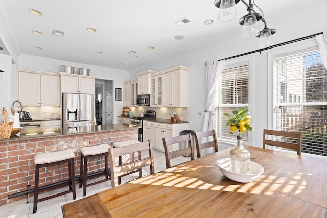 tiled dining space featuring ornamental molding and sink