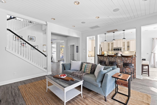 living room featuring wood-type flooring, wooden ceiling, and crown molding