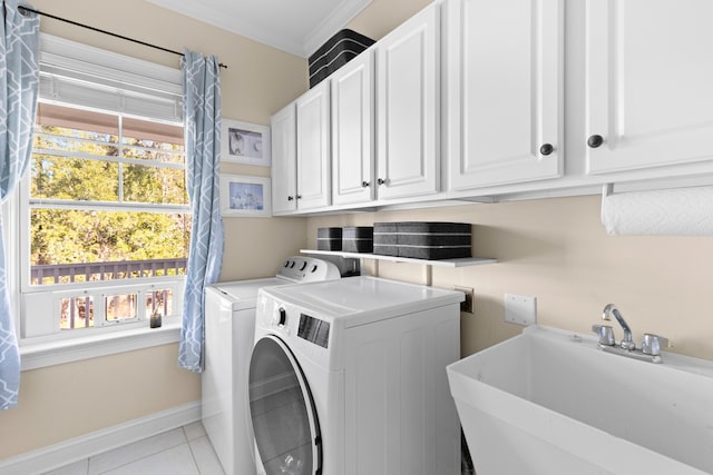 washroom featuring light tile patterned flooring, washing machine and clothes dryer, sink, crown molding, and cabinets