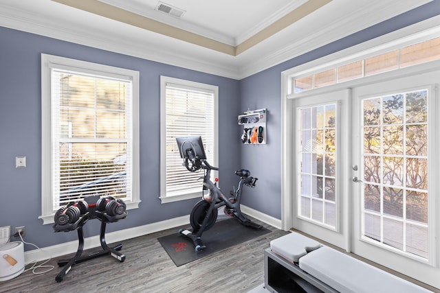 exercise room with ornamental molding and hardwood / wood-style floors