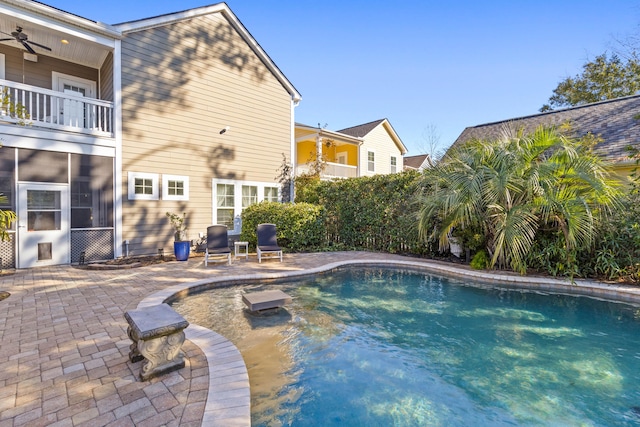 view of swimming pool with a patio, a sunroom, and ceiling fan