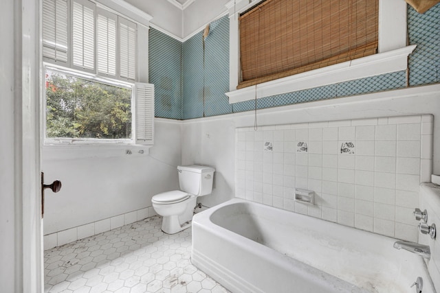 bathroom with tile patterned floors, a washtub, and toilet