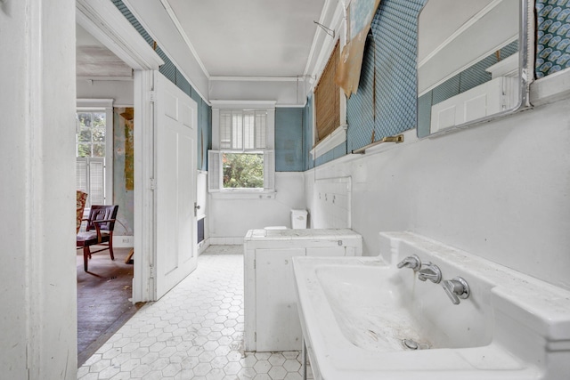 bathroom with washer and dryer, ornamental molding, and sink