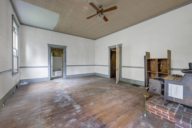 interior space with hardwood / wood-style floors, ceiling fan, and wood walls