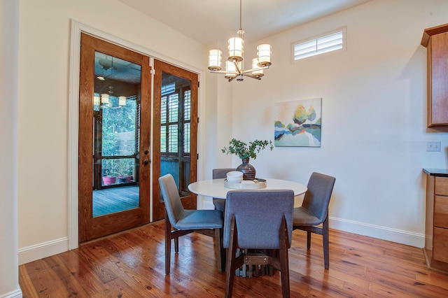 dining area featuring french doors, a chandelier, and hardwood / wood-style floors