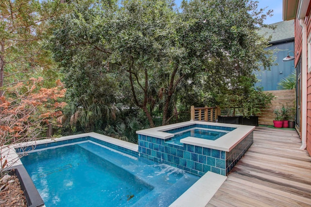 view of pool with a deck and an in ground hot tub