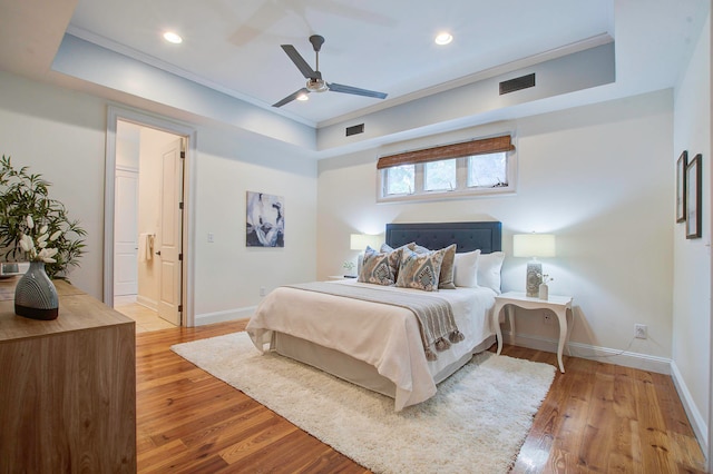 bedroom featuring light wood-type flooring, ceiling fan, ensuite bathroom, and crown molding