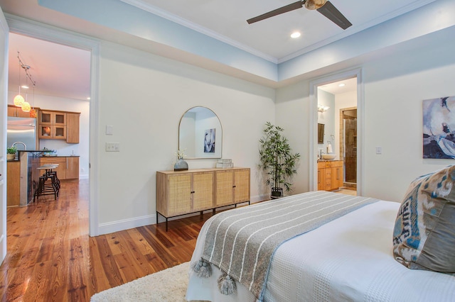 bedroom with ornamental molding, dark wood-type flooring, ceiling fan, and ensuite bath