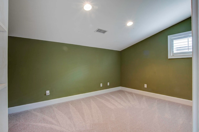 empty room featuring carpet floors and vaulted ceiling