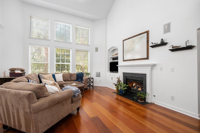 1977 Pierce St, Charleston, SC 29492 - living area featuring baseboards, a high ceiling, a fireplace with flush hearth, built in shelves, and wood finished floors