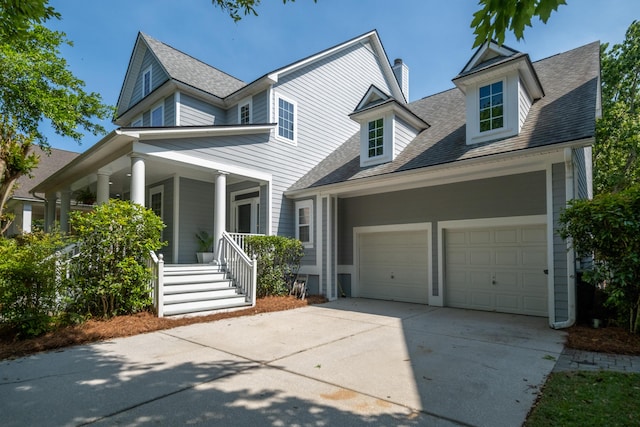 1977 Pierce St, Charleston, SC 29492 - view of front of home with a shingled roof, an attached garage, covered porch, a chimney, and concrete driveway