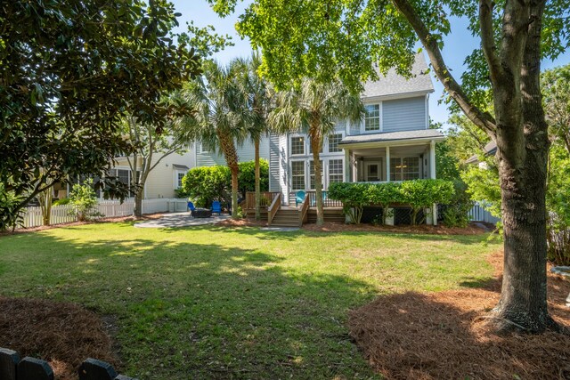 1977 Pierce St, Charleston, SC 29492 - back of property with a yard, a wooden deck, fence, and a shingled roof