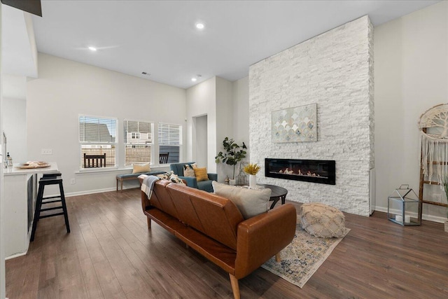 living room featuring dark wood-type flooring and a fireplace