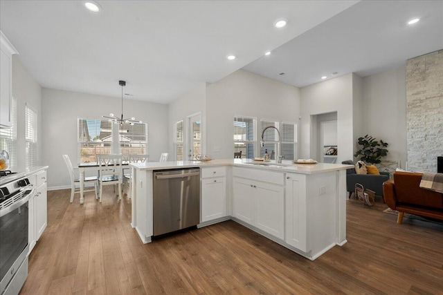 kitchen with light hardwood / wood-style flooring, sink, pendant lighting, white cabinetry, and appliances with stainless steel finishes