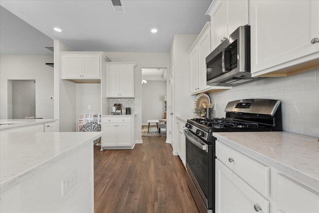 kitchen featuring light stone countertops, stainless steel appliances, white cabinets, and dark hardwood / wood-style flooring