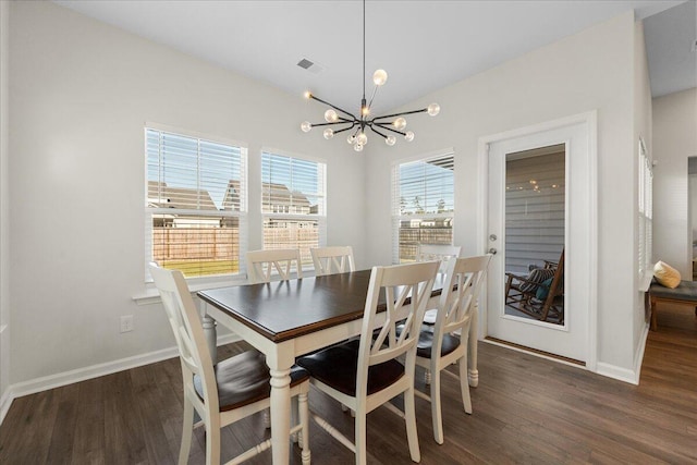 dining area with dark hardwood / wood-style floors and a chandelier